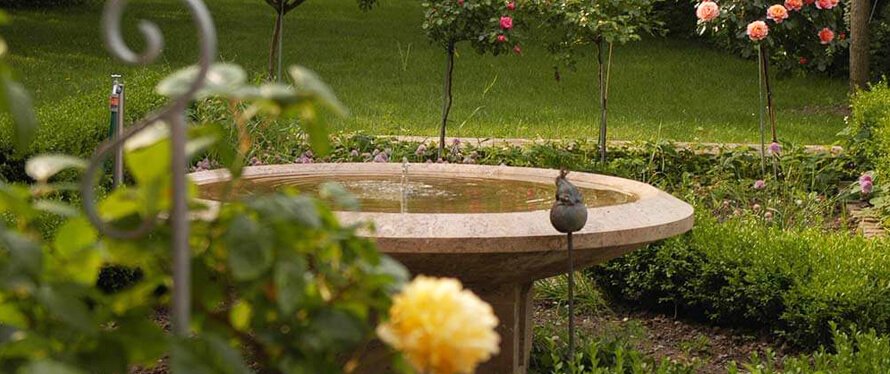 Gartenbrunnen aus Stein im Rosengarten