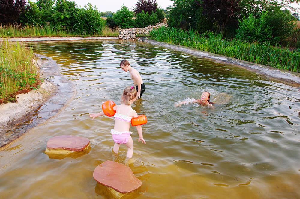 Schwimmteich mit spielenden Kindern