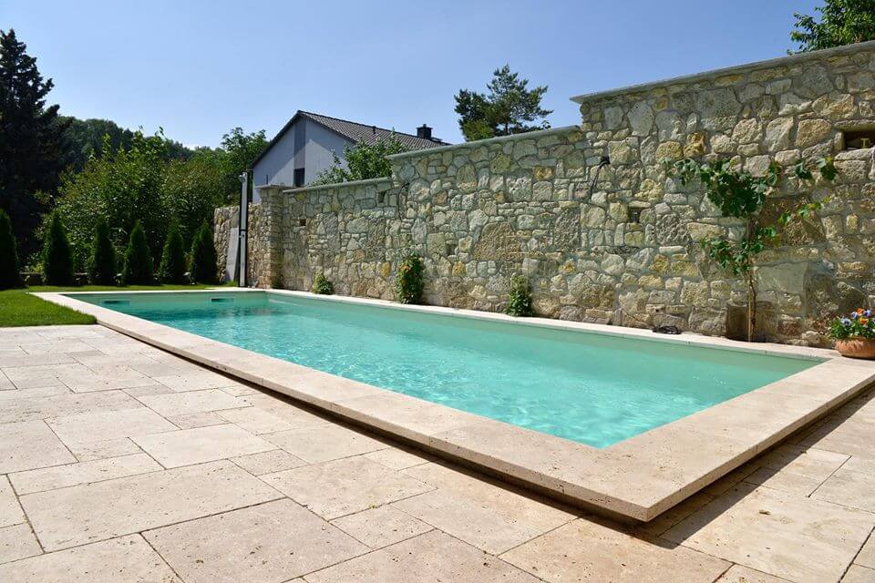Natursteinmauer als Sichtschutz für den Pool