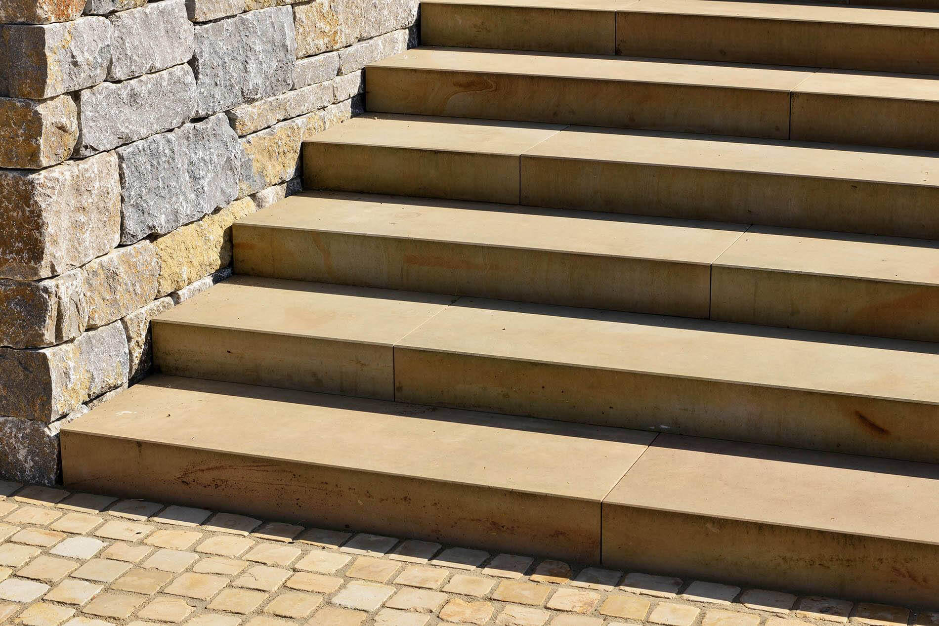 Steintreppe neben naturbelassener Wandverkleidung